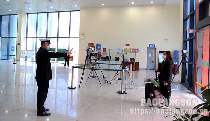 Cán bộ Kiểm dịch y tế quốc tế tại Cửa khẩu Quốc tế Hữu Nghị hướng dẫn khách nhập cảnh vào khu vực đo thân nhiệt tự động