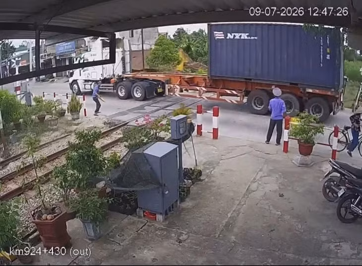 Chiếc container vẫn lao qua đường sắt dù còi, đèn tín hiệu đã bật, gác chắn đang hạ - Ảnh: Cắt từ video