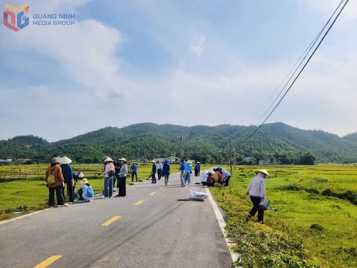 Hội viên nông dân thôn Bản Sen dọn vệ sinh tuyến đường hoa của thôn.