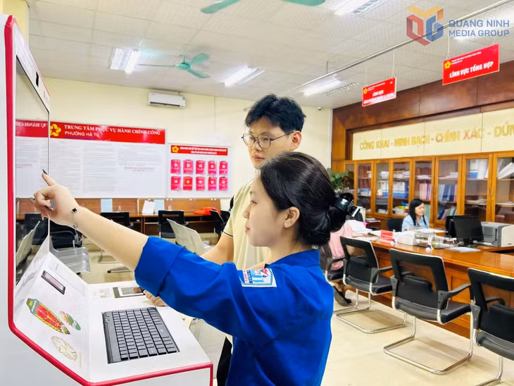 Thanh niên tình nguyện phường Hà Tu hỗ trợ người dân sử dụng máy Kiosk tại Trung tâm Phục vụ Hành chính công phường.