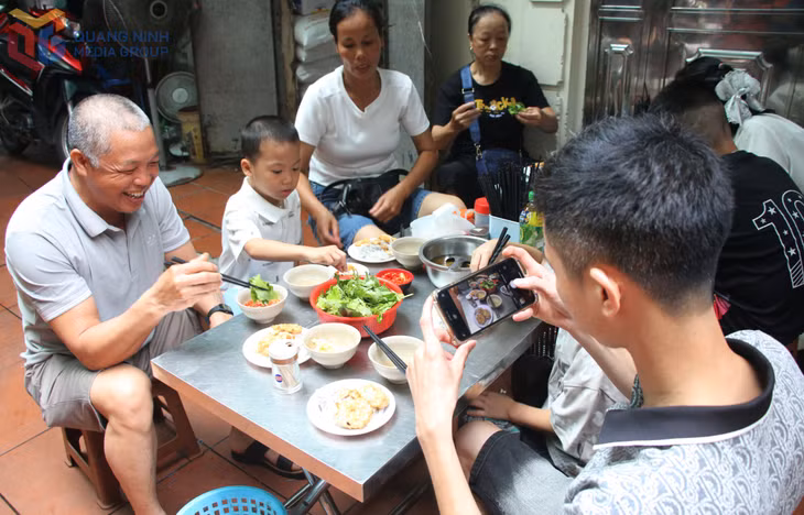 Du khách hào hứng lưu lại hình ảnh món bánh cuốn chả mực trước khi thưởng thức.