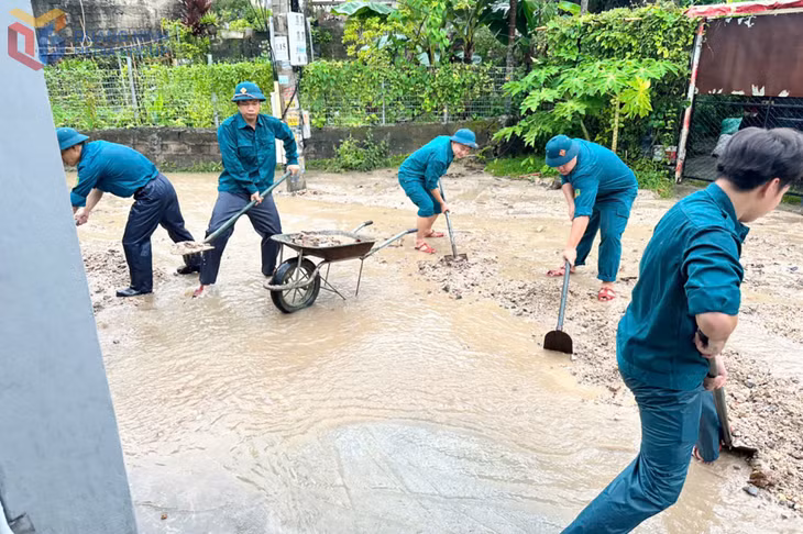 Cán bộ, chiến sĩ Ban CHQS phường Hà Lầm phối hợp với các lực lượng hỗ trợ nhân dân thu dọn đất, cát do sạt lở tại khu Cao Thắng 4.