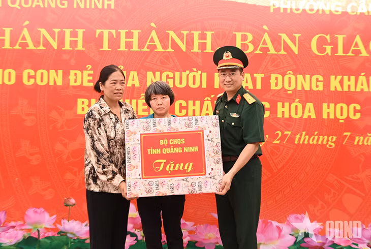 Thượng tá Nguyễn Văn Việt, Phó chính ủy Bộ CHQS tỉnh trao quà tặng bà Đỗ Thị Định, tại buổi khánh thành, bàn giao nhà tình nghĩa ở khu phố 11, phường Cẩm Phả.&nbsp;Ảnh: Văn Đảm