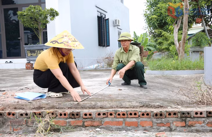 Bí thư Chi bộ khu Tràng An 2 Bùi Thị Nhường (phường Bình Khê) kiểm tra phần diện tích người dân hiến đất thực hiện dự án cải tạo, mở rộng đường trong khu dân cư.