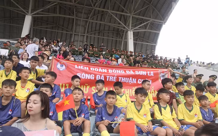 Các cầu thủ bóng đá trẻ Thuận Châu cùng với băng rôn cũng tham gia cổ vũ cho đội chủ nhà Sơn La.