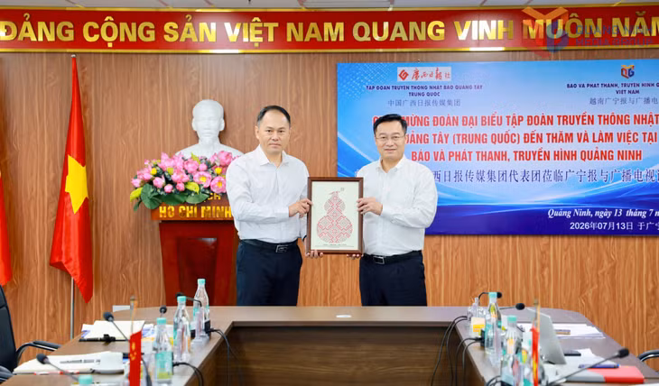 Đồng chí Nguyễn Thế Lãm, Giám đốc Báo và Phát thanh, Truyền hình Quảng Ninh và ông La Mạnh, Phó Tổng Biên tập Nhật báo Quảng Tây, trao quà lưu niệm nhân dịp hội đàm.