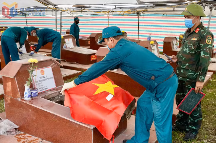 Các lực lượng thực hiện quy trình khai quật mở nắp các phần mộ liệt sĩ.