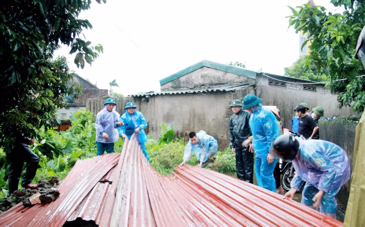 Lực lượng chức năng xã Hải Ninh hỗ trợ người dân dọn dẹp.