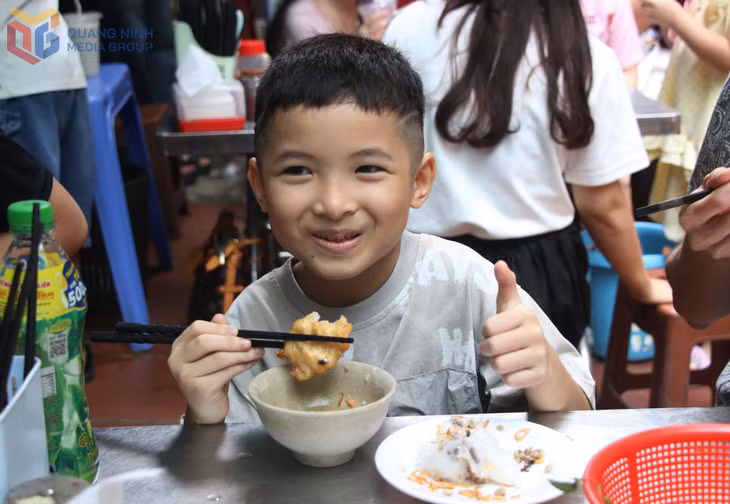 Em bé thích thú thưởng thức món bánh cuốn chả mực.