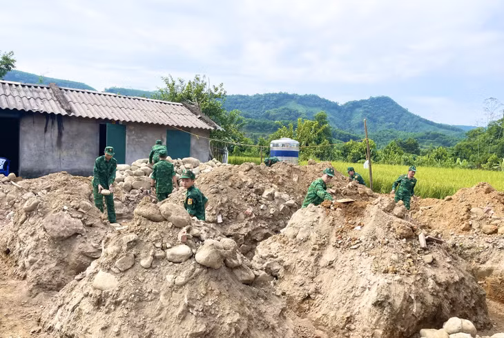 Cán bộ, chiến sĩ Đồn Biên phòng Quảng Đức hỗ trợ ngày công giúp gia đình chị Lý Thị Thắm, bản Chăn Mùi, xã Quảng Đức (Hải Hà) xây nhà ở. Ảnh: Thái Hà (Trung tâm TT&VH Hải Hà)