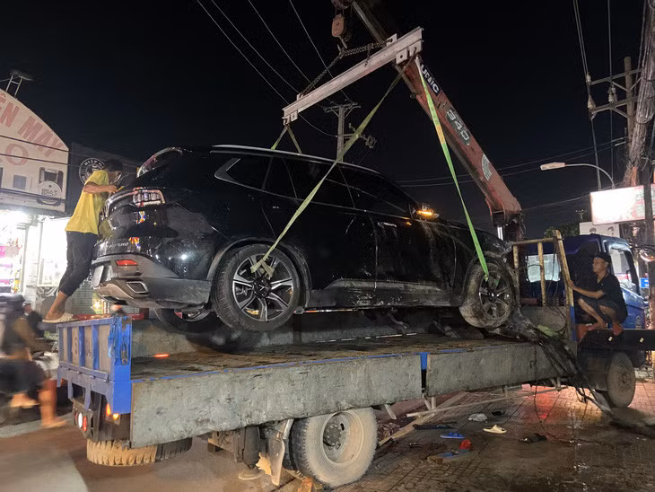 Ô tô tông hàng loạt xe máy và ô tô khác được cẩu đi khỏi hiện trường - Ảnh: HOÀNG HƯỜNG