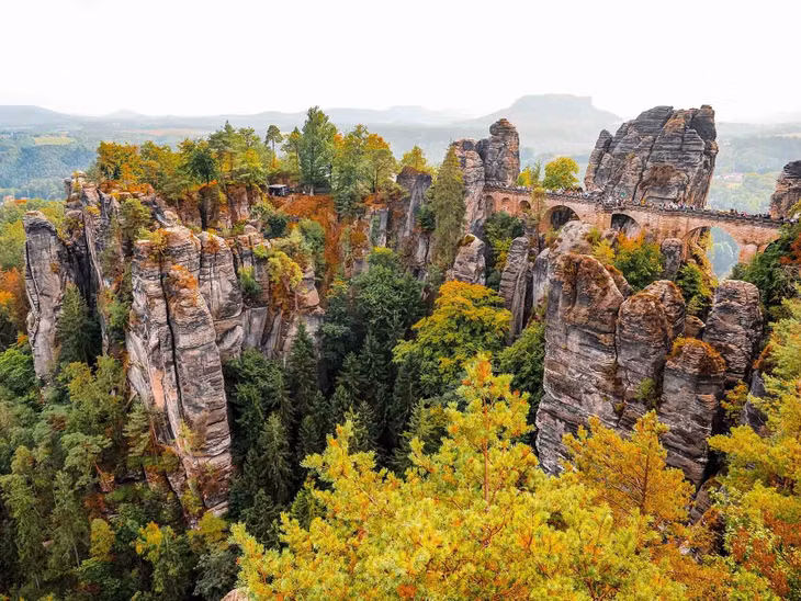 Cách trung tâm thành phố Dresden khoảng 40km, Bastei là một vùng núi đá cổ, hình thành cách đây hàng triệu năm. Nơi đây nổi tiếng với cây cầu đá Bastei. Đứng trên cầu vào mùa Thu, du khách có thể chiêm ngưỡng cánh rừng đang chuyển màu, những tảng đá hùng vĩ cùng dòng sông Elbe thơ mộng. Ảnh: Hang Van Photography