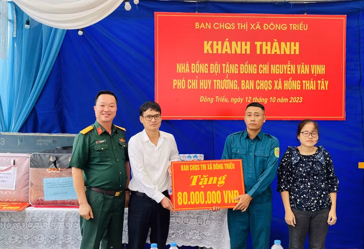 Đại diện lãnh đạo thị xã Đông Triều, Ban CHQS thị xã trao tiền hỗ trợ xây nhà đồng đội.