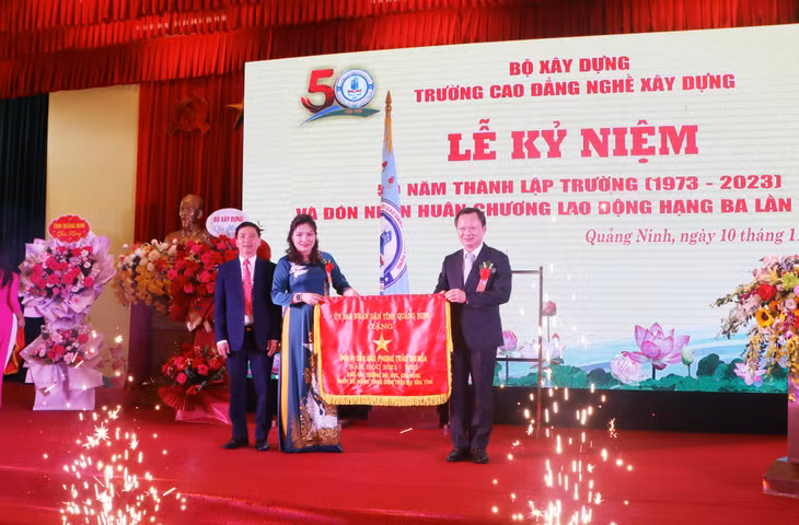 Đồng chí Cao Tường Huy, Quyền Chủ tịch UBND tỉnh, trao tặng Cờ đơn vị dẫn đầu phong trào thi đua năm học 2022-2023 cho Trường Cao đẳng nghề Xây dựng.