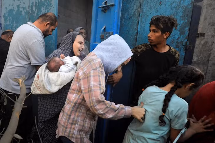 Người dân vội vã sơ tán khỏi các ngôi nhà ở trại tị nạn al-Maghazi. Ảnh: Reuters