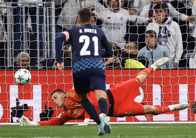 Lunin cản pha đá phạt đền đầu trận của Alvaro Djalo. Ảnh: Reuters