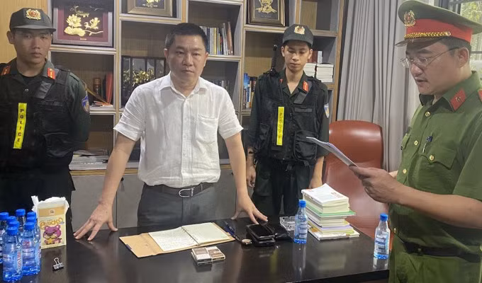 Công an đọc lệnh bắt Nguyễn Khánh Hưng (áo trắng). Ảnh: Thái Hà