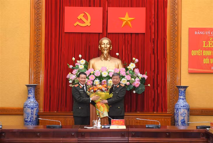 Bộ trưởng Tô Lâm tặng hoa chúc mừng thiếu tướng Vũ Hồng Văn - Ảnh: Bộ Công an