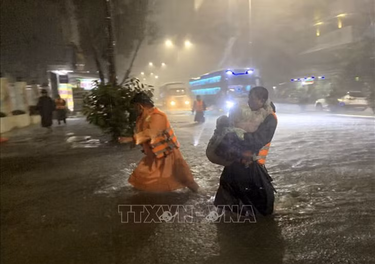 Lực lượng chức năng phường Hòa Khánh Nam (quận Liên Chiểu, Đà Nẵng) khẩn trương đưa trẻ em tại các hộ dân bị ngập đến nơi an toàn. Ảnh: TTXVN phát