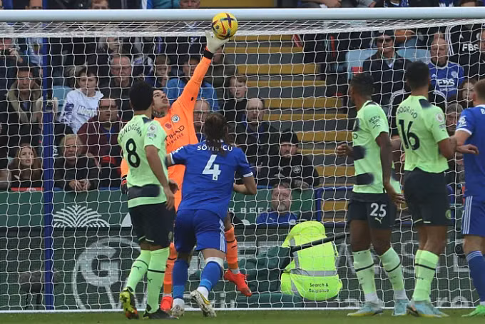 Ederson bay người đấm bóng dội xà sau pha vô-lê của Tielemans. Ảnh: AFP.