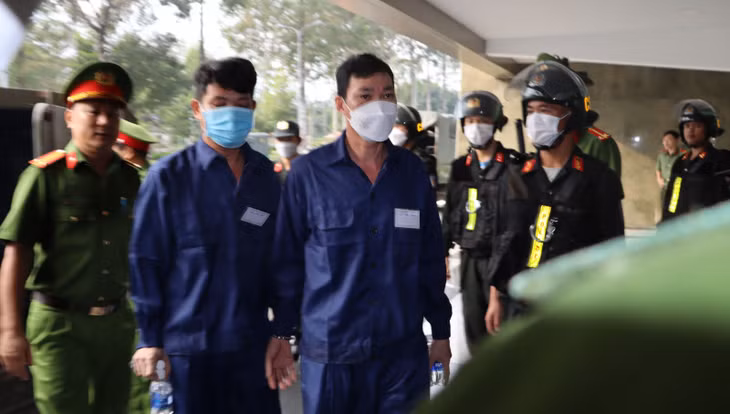 Công an áp giải các bị cáo đến tòa.