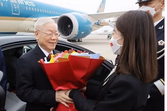 Nghi thức tặng hoa chào mừng tại lễ đón Tổng Bí thư Nguyễn Phú Trọng và Đoàn đại biểu cấp cao Đảng Cộng sản Việt Nam ở sân bay quốc tế Bắc Kinh. Ảnh TTXVN