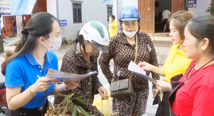 Cán bộ BHXH huyện Tiên Yên tuyên truyền, vận động người dân trên địa bàn tham gia BHYT hộ gia đình.