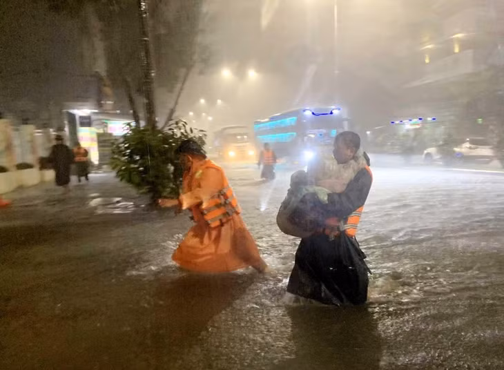 Lực lượng chức năng phường Hòa Khánh Nam (quận Liên Chiểu, TP Đà Nẵng) khẩn trương đưa trẻ em tại các hộ dân bị ngập đến nơi an toàn.