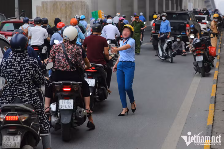 Một người phụ nữ giúp người bị tai nạn giao thông tại hầm chui Nguyễn Trãi