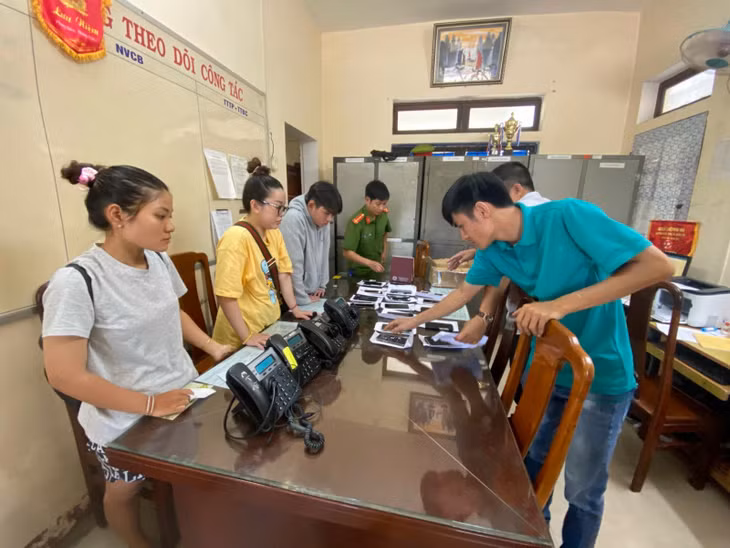 Lại Ngọc Đoan Trang (thứ hai), Nguyễn Văn Trường (thứ 3, bìa trái) cùng một số tang vật mà các đối tượng sử dụng gọi điện lừa đảo.
