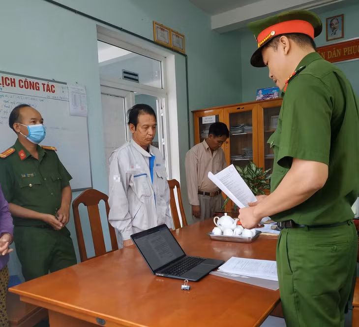 Nguyễn Văn Quân nghe đọc lệnh bắt tạm giam. Ảnh: CA
