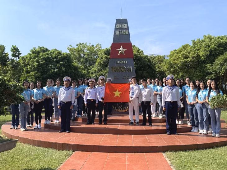 Ban Tổ chức, các thí sinh và cán bộ chiến sĩ Lữ đoàn 147 Hải quân chụp ảnh lưu niệm tại mô hình cột mốc chủ quyền trên Đảo Trường Sa được dựng trong khuôn viên Lữ đoàn.