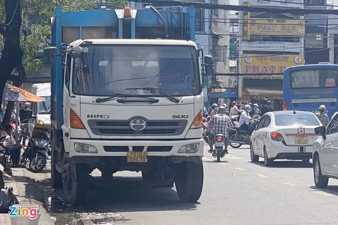 Xe chở rác được lực lượng chức năng đưa vào lề đường. Ảnh: A.H.