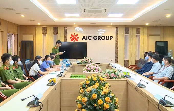 Cảnh sát đọc lệnh khám xét trụ sở AIC, ngày 29/4. Ảnh: Phạm Mai