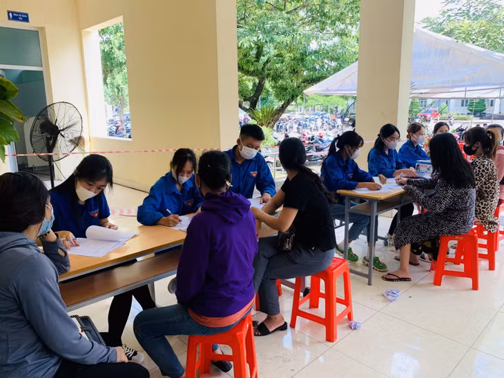 ĐVTN hỗ trợ người dân điền thông tin cá nhân vào phiếu khám sàng lọc tiêm vắc xin phòng Covid-19.