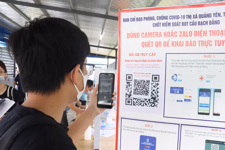 Các em học sinh thực hiện quét mã QR khai báo y tế tại chốt kiểm soát.
