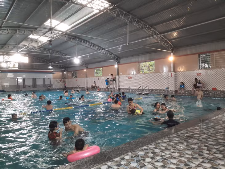 Các bậc phụ huynh cho con học bơi trong dịp hè tại bể bơi Bốn mùa của Trường TH-THCS-THPT Lê Thánh Tông (TP Hạ Long).