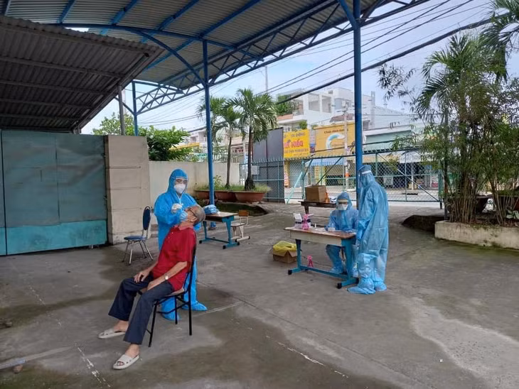 Người dân đến xét nghiệm COVID-19 bằng test nhanh và nghe các tư vấn phòng dịch ở trạm y tế lưu động. Ảnh: VGP/Hà Đạo