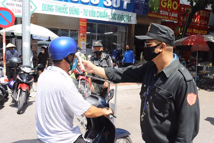 Người dân vào chợ đều được đo thân nhiệt để phòng dịch.