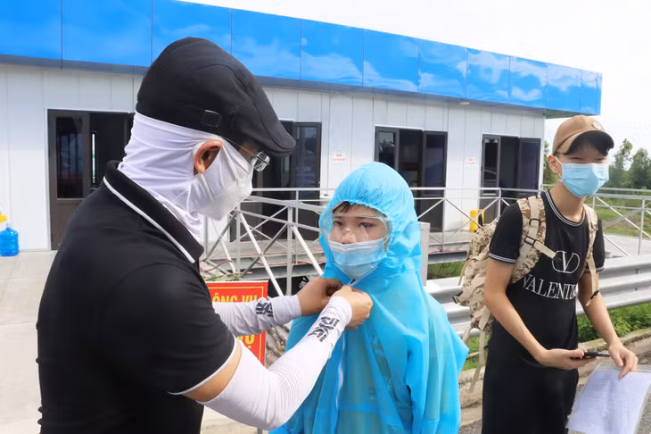 Nhiều người cẩn thận mặc đồ bảo hộ cho con em mình trước khi lên xe.