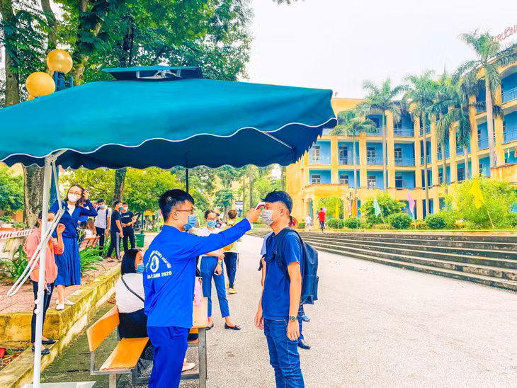 Sinh viên Trường Đại học Công Nghiệp Quảng Ninh được đo thân nhiệt khi đến trường.