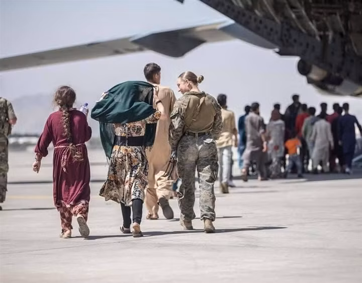 Nữ binh sỹ Mỹ hỗ trợ người sơ tán ở sân bay Kabul. (Ảnh: NYT)