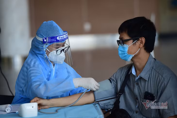 Người dân đi tiêm vắc xin. Ảnh: Trương Thanh Tùng Có nên uống thuốc chống dị ứng trước khi tiêm vắc xin Covid-19?