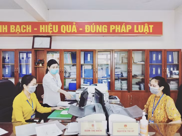 Bí thư Đảng ủy phường Cẩm Thạch (TP Cẩm Phả) Nguyễn Thị Tụ (áo trắng), hướng dẫn cán bộ làm việc tại bộ phận một cửa của phường.