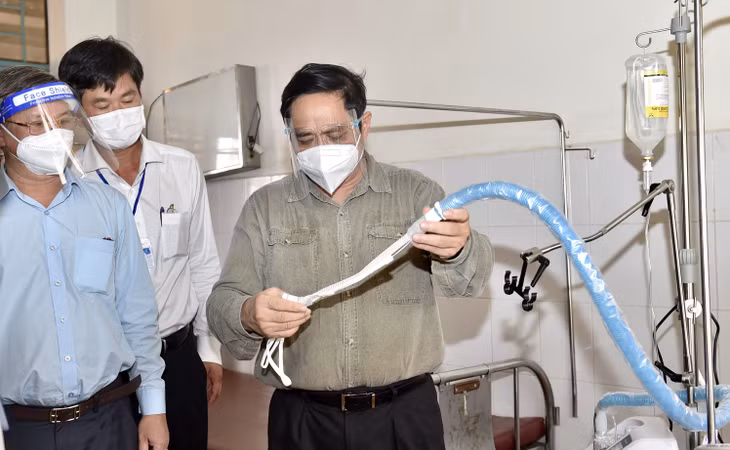 Thăm Bệnh viện Đa khoa huyện Vinh Cửu, Thủ tướng kiểm tra thiết bị cung cấp ô xy tại đây. Ảnh: VGP/Nhật Bắc
