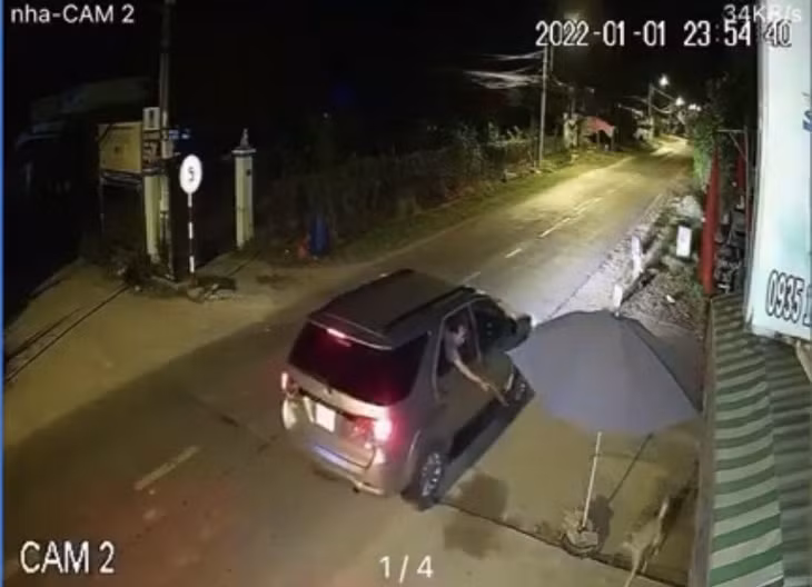 Đối tượng ngồi trong xe dùng súng chích điện bắn con chó. Ảnh cắt từ clip.