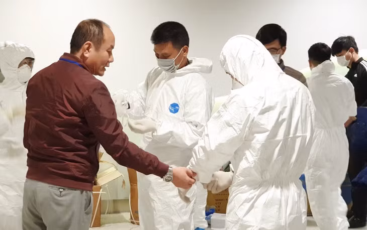 Bác sĩ Nguyễn Quốc Hùng hướng dẫn cán bộ thực hiện nhiệm vụ tại sân bay quốc tế Vân Đồn mặc đồ phòng hộ cá nhân để đón 30 công dân từ Vũ Hán (Trung Quốc) về nước, tháng 2/2020.