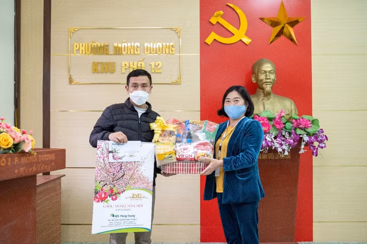Bà Phạm Thúy Hà, đại diện AES Mông Dương, Quảng Ninh trao quà tết cho hộ dân có hoàn cảnh khó khăn.