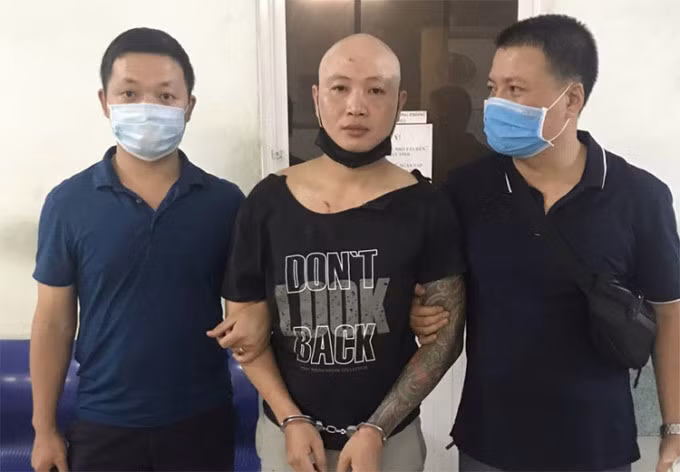 Nguyễn Văn Sơn (giữa) tại cơ quan điều tra. Ảnh: Công an cung cấp