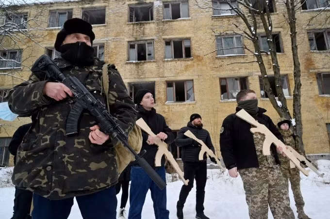 Quân nhân Ukraine huấn luyện tình nguyện viên cầm súng tại một nhà máy bỏ hoang tại Kiev ngày 30/1. Ảnh: AFP.